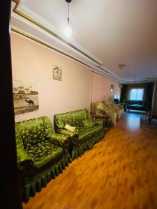 a living room with green couches and a couch at luxurious apartment in Az Zaqāzīq