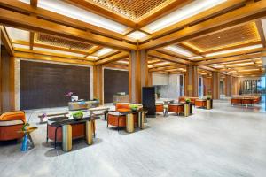 a lobby with tables and chairs and a chalkboard at MORAZEN Yogyakarta in Temon