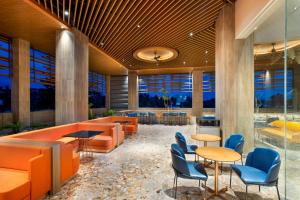 a lobby with orange furniture and blue chairs at MORAZEN Yogyakarta in Temon