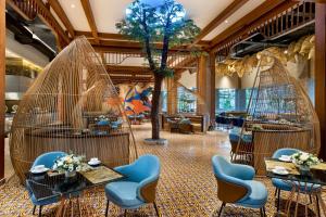 a lobby with chairs and tables and a tree at MORAZEN Yogyakarta in Temon