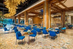 a dining room with blue chairs and tables at MORAZEN Yogyakarta in Temon