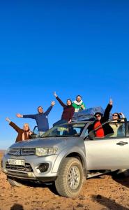 een groep mensen die achterin een vrachtwagen zitten bij Excreción erg chegaga 2 jour départ zagora 4x4 in Zagora