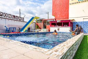 a group of people playing in a swimming pool at Complexe Meublé PEPON in Douala