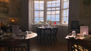 un comedor con mesas y sillas y una ventana en Whitecliff Guest House en Weymouth