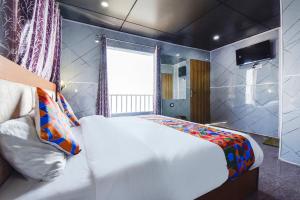 达纳尔蒂FabHotel Neilkanth的带一张大床和一扇窗户的卧室