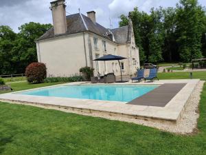 ein Haus mit Pool davor in der Unterkunft Chambres d'hôtes chez Sylvie in Donnemain-Saint-Mamès