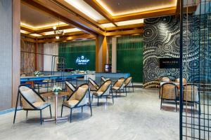 a restaurant with chairs and tables and a bar at MORAZEN Yogyakarta in Temon