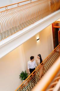 a bride and groom standing on a staircase at 1962 Garden Inn in Hue