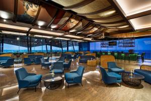 a waiting room with blue chairs and tables at MORAZEN Yogyakarta in Temon