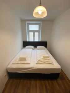 a large bed in a room with a window at Nearby Trainstation Meidling in Vienna