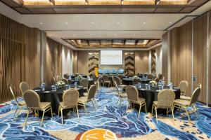 a conference room with tables and chairs and a screen at MORAZEN Yogyakarta in Temon