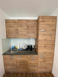 a kitchen with wooden cabinets and a sink at Nearby Trainstation Meidling in Vienna