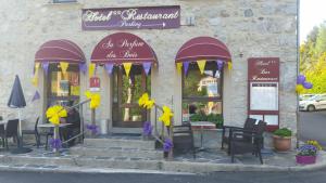 um restaurante com decorações roxas e amarelas em frente em Au Parfum des Bois em Saint-Cirgues-en-Montagne