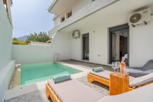 a villa with a swimming pool and a house at Poseidon close to the beach in Agios Nikolaos