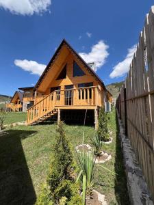een houten huis met een hek ervoor bij The Mountain Villas in Hankavan