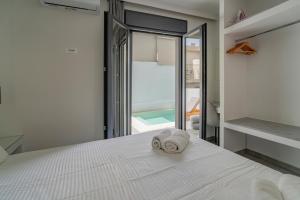 a bedroom with a white bed with a towel on it at Poseidon close to the beach in Agios Nikolaos +25 photos
