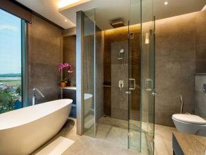 a bathroom with a tub and a glass shower at MORAZEN Yogyakarta in Temon