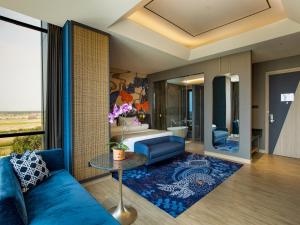 a living room with a blue couch and a table at MORAZEN Yogyakarta in Temon