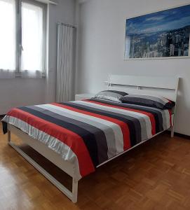 1 dormitorio con 1 cama con manta a rayas en Camera LOW COST in alloggio condiviso Stanza 1 en Crema