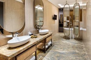 two sinks in a bathroom with two mirrors at MORAZEN Yogyakarta in Temon