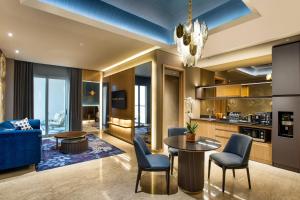 a living room with a blue couch and a table and chairs at MORAZEN Yogyakarta in Temon