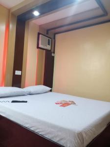 アンヘレスにあるHotel Sogo Mexico Pampangaのベッド1台と壁掛けテレビが備わる客室です。