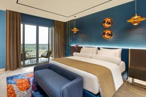 a bedroom with a large bed and a blue wall at MORAZEN Yogyakarta in Temon