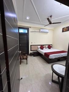 Cozy homestay Varanasi في فاراناسي: غرفة نوم بسرير وكرسي في غرفة