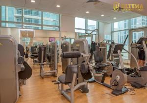 Ultima Vacation Homes loft 1 BR Apartment في دبي: صالة ألعاب رياضية مع صفوف من أجهزةالجري والأجهزة البيضية