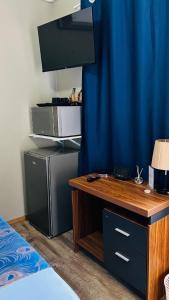 a desk in a room with a blue curtain at Shiloh Inn in Gaborone