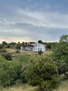 een wit huis in het midden van een veld bij Finca Altair in Madrid