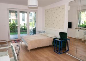 a bedroom with a bed and a chair and windows at Puck Nexo apartament u Doroty 2os in Puck