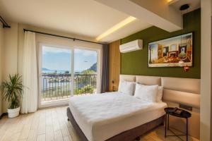 1 dormitorio con cama y ventana grande en Morina Deluxe Hotel en Ölüdeniz