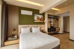 1 dormitorio con cama blanca y pared verde en Morina Deluxe Hotel en Ölüdeniz