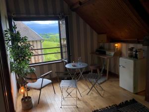 a small kitchen with a table and a window at Chambre vue sur la vallée in Crouttes