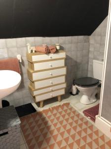 a bathroom with a dresser and a toilet and a sink at Chambre vue sur la vallée in Crouttes