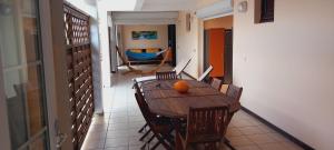 a dining room with a table and chairs with an orange on it at Vacances martinique in Sainte-Anne