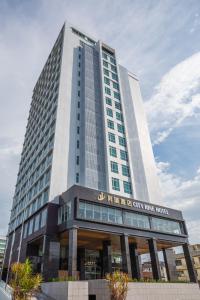 a tall building with a sign on the front of it at City Rise Hotel Miri in Miri