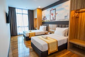 um quarto de hotel com duas camas e um quadro na parede em City Rise Hotel Miri em Miri