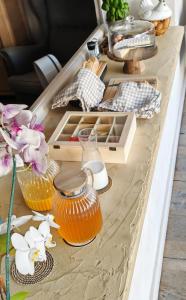 una mesa con recipientes de vidrio de miel y flores. en Hôtel de la Corniche d'Or, en Mandelieu-la-Napoule