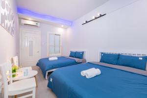 dwa łóżka w pokoju z niebieską pościelą i stołem w obiekcie 165A Nice Apartment VT w mieście Vung Tau