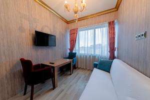 een hotelkamer met een bed, een bureau en een televisie bij Royal Babil Suites Hotel in Trabzon