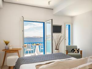 a bedroom with a bed and a view of the ocean at Bluetopia Suites in Mikonos