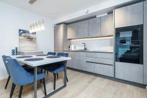 une cuisine avec une table à manger et des chaises bleues dans l'établissement Dream Stay - Modern Design Apartments with Balcony & Free parking, à Tallinn