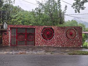 una pared de ladrillo rojo con ventanas rojas y una puerta en Quinta Los Tercos, en Santiago
