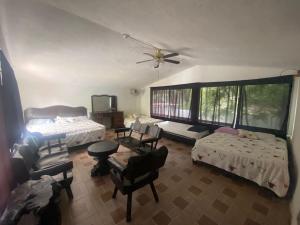 a living room with two beds and a couch and chairs at Quinta Los Tercos in Santiago