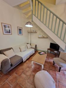 a living room with a couch and a staircase at Le Logis Saint Roch in Pézenas
