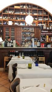 un restaurante con mesas blancas y botellas de vino en SUITE Corso Roma, en Cerignola