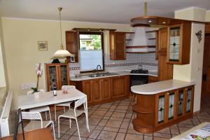 a kitchen with wooden cabinets and a white table at Apartment JANG in Tolmin