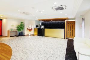 a living room with a couch and a refrigerator at Sasebo Green Hotel in Sasebo